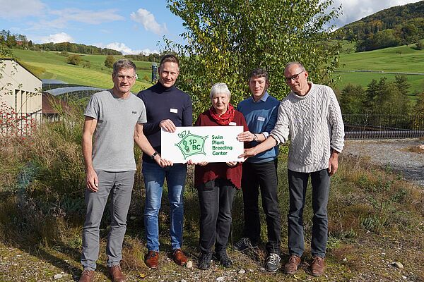Vier Männer und eine Frau vor grünem Hintergrund halten ein Schild mit dem SPBC Logo.